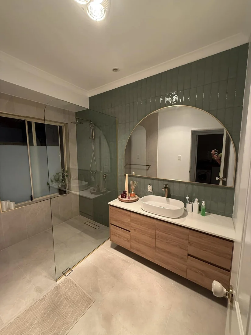 Completed bathroom with a timber vanity and round mirror
